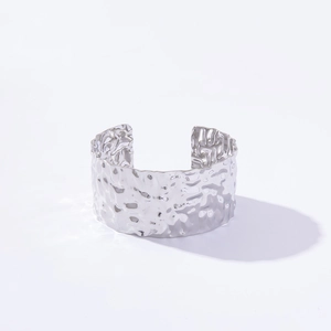 Detailed close-up of a silver-colored adjustable cuff bracelet with hammered texture finish