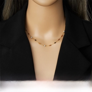 Detail of gold-plated stainless steel chain necklace with colorful stone beads on a model