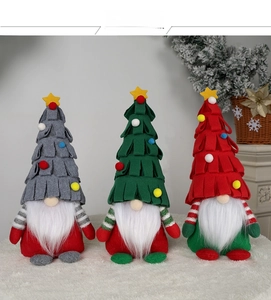 Tre gnomi di Natale in peluche con cappelli ad albero su un tappeto di pelliccia