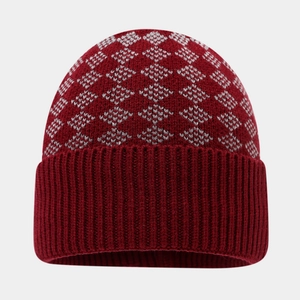 Detail view of burgundy beanie with grey geometric diamond patterns and ribbed knit cuff