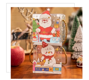 Detail of cartoon Christmas PVC gift boxes with gold handles on a wooden table setup