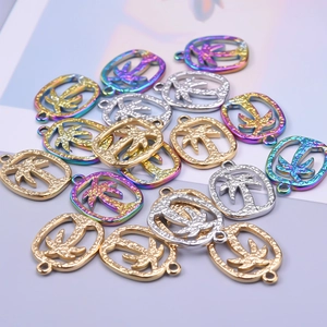 Detailed view of stainless steel coconut tree pendants in gold, silver, and rainbow finishes