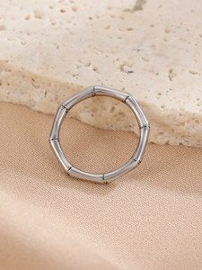 Detailed view of silver bamboo texture ring resting on beige travertine stone