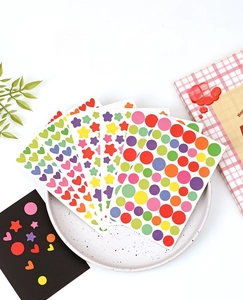 Detail of colorful macaron star, heart and round stickers on a textured tray