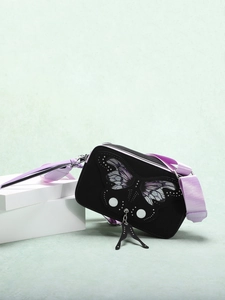 Detail of black crossbody bag with purple butterfly embroidery and silver rivets