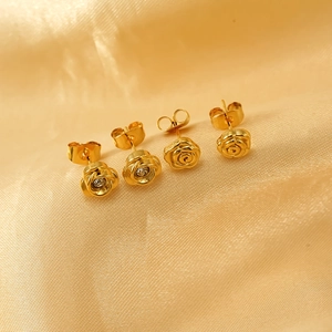 Golden stainless steel 3D rose earrings with zircon inlay on luxury silk background