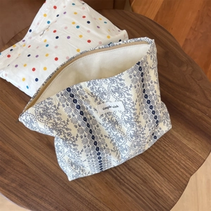 Detailed macro of fabric pouch featuring blue lace floral print and simple wish label