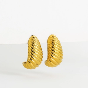 Macro detail of 18K gold plated croissant hoop earrings with sculptural ribbed texture