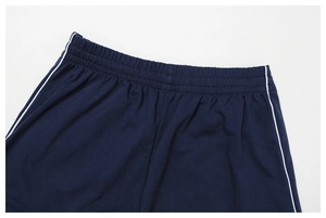 Dettaglio della fascia elastica in vita con strisce bianche su pantaloncini navy