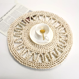 Détail d'un set de table en paille tressée avec bordure dentelle et tasse décorative