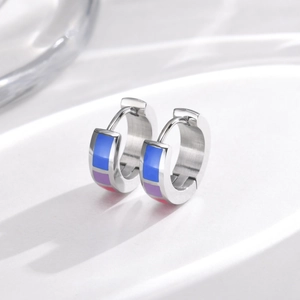 Macro detail of stainless steel hoop earrings with rainbow enamel inlay and brushed finish