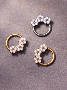 Detailed view of silver and gold nose rings set with sparkling clustered zircons