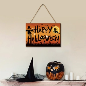 Wooden Happy Halloween pumpkin sign hanging on wall with rustic decorative fall ornaments