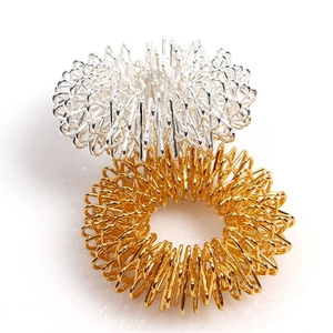 Close-up of gold and silver metallic spring massage rings for finger acupressure relief