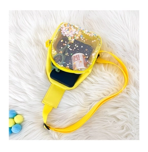 Detail view of yellow crossbody bag showing storage space with colorful star sequins