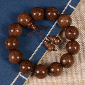 Detailed view of dark brown Phoebe zhennan wood prayer beads with gourd charms