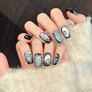 Winter snowflake press-on nails with blue cat-eye finish and sparkling rhinestones