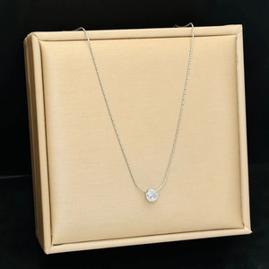 Close-up of silver titanium steel necklace with a round claw-set diamond pendant