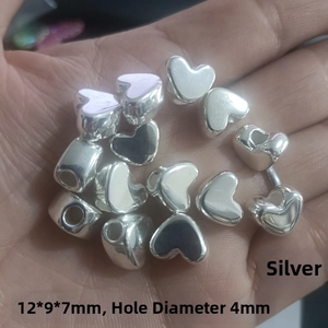 Detailed view of silver heart-shaped CCB spacer beads sized 12x9x7mm with 4mm hole
