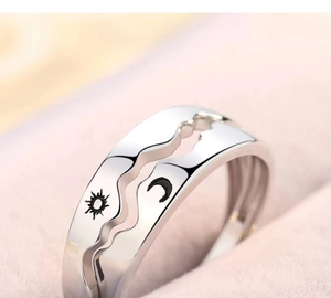 Macro detail of interlocking silver sun and moon rings with matching wave edges