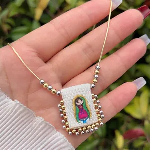 Handheld view of 18K gold plated snake chain with a Virgin of Guadalupe bead pendant