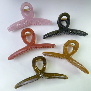 Détail de cinq grandes pinces à cheveux en résine en rose orange noir et marron ambre