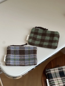 Close-up of wool plaid coin purse with simple wish label and brown zipper puller
