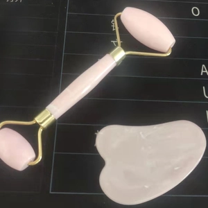 Pink quartz facial roller and heart-shaped gua sha set with gold-tone hardware tools