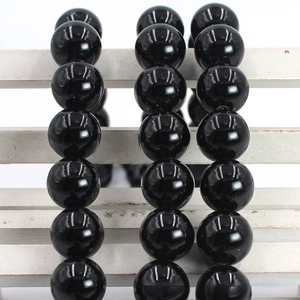 Macro shot of polished black agate round beads with glossy mirror finish for DIY jewelry