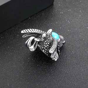 Macro detail of a punk style dragon wing pendant with turquoise inlay and vintage finish