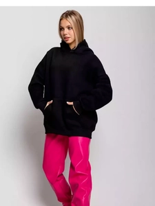 Women's oversized black hoodie and shiny pink trousers in a street style winter outfit