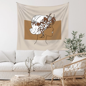Detail of minimalist bohemian wall tapestry featuring line art face in a cozy home setting