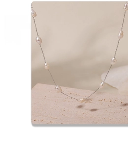 Macro view of natural freshwater baroque pearls on a minimalist silver chain necklace