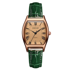 Gros plan détaillé d'une montre dorée tonneau avec bracelet en cuir gaufré vert