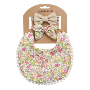 Boho-Lätzchen mit Blumenmuster und Stirnband-Set mit Pompons auf weißem Karton