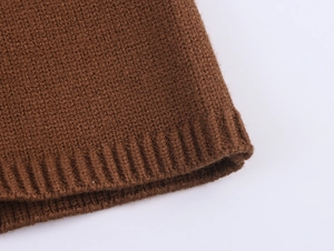Detail of brown knit fabric showing the ribbed texture and high-quality hem stitching