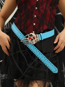 Detail of blue punk belt with double-row studs and large silver skull buckle closure