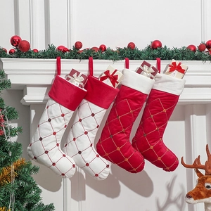 4er-Set rote und weiße Weihnachtsstrümpfe aus Samt mit Pailletten am Kamin aufgehängt