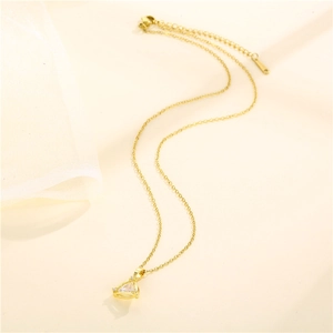 Elegant gold triangle necklace with sparkling crystal pendant on beige and white background