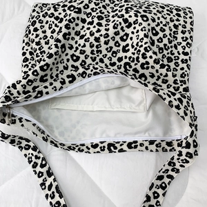 Detail of leopard print canvas tote bag with a secure zip closure and internal phone pocket
