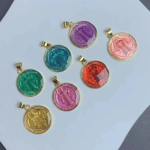 Colorful Saint Benedict enamel pendants with gold metal frames shown in various vibrant colors