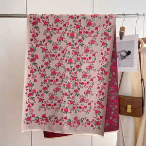 Close-up of double-sided cashmere scarf with red rose pattern and fringe detail
