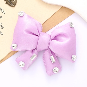 Macro shot of light purple satin bow accessory with sparkling rhinestone details