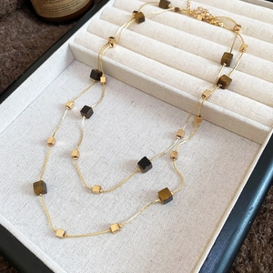 Detail showing double layer necklace with tiger eye beads and lobster clasp in jewelry box