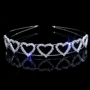 Detail of silver heart crown with sparkling rhinestones and hollow metal design