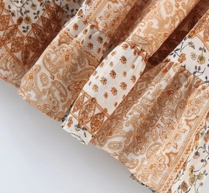 Close-up of paisley floral fabric texture and ruffled hemline of the summer dress