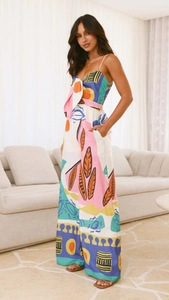 Detail of multi-color floral print jumpsuit featuring a front tie and wide leg design