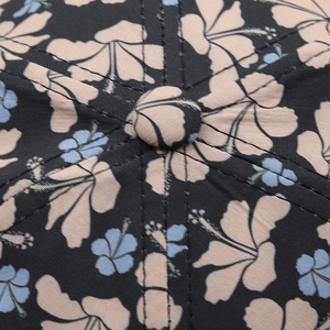 Close-up of top button and seams on black tropical floral print baseball cap