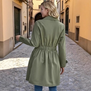 Detail of olive green trench coat back showing the elastic waist and flared hem design