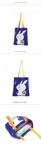 Detail of blue knitted tote bag with white rabbit pattern and yellow straps showing capacity